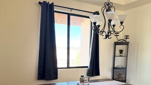 Un comedor con mesa de madera, banco y candelabro.