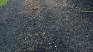 A gravel driveway leading to a building with a brick exterior and large windows. - Luxury holiday cottage, stunning views, and hot tub. (Pingjum)