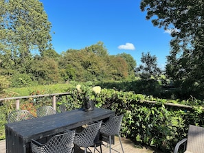 Relax in a serene outdoor space surrounded by lush greenery and a distant view.