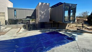 A modern building with a pool area, including a covered patio and a large window. - Modern Private Casita • Bright, Quiet, Minutes to LANL & Trails (Los Alamos)