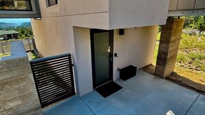 A modern building with a flat roof, concrete pillars, and a small entrance with a door. - Modern Private Casita • Bright, Quiet, Minutes to LANL & Trails (Los Alamos)