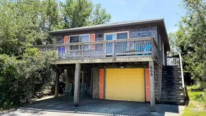 Ein zweistöckiges Haus mit Balkon, Garage und einer Treppe, die zum oberen Stock führt.