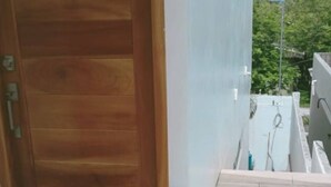 Una puerta de madera, una pared blanca y un suelo de baldosas.