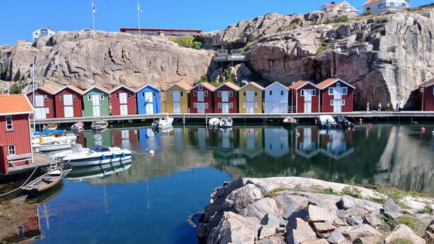 A harbor with colorful wooden houses, boats, and rocky cliffs. - Smögen large rooms, on lovely Stenrös. (Västra Götalands län)