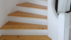 A staircase with white walls and wooden steps. - Smögen large rooms, on lovely Stenrös. (Västra Götalands län)
