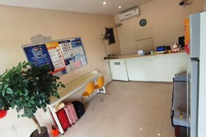 A hotel room with a bed, a desk, a chair, a plant, and a bulletin board. - Jialu Hostel (Shanghai)