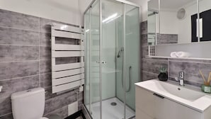 A modern bathroom with a glass-enclosed shower, a white sink, and a towel rack. - Le Van Gogh - In the Heart of Arles (Arles)