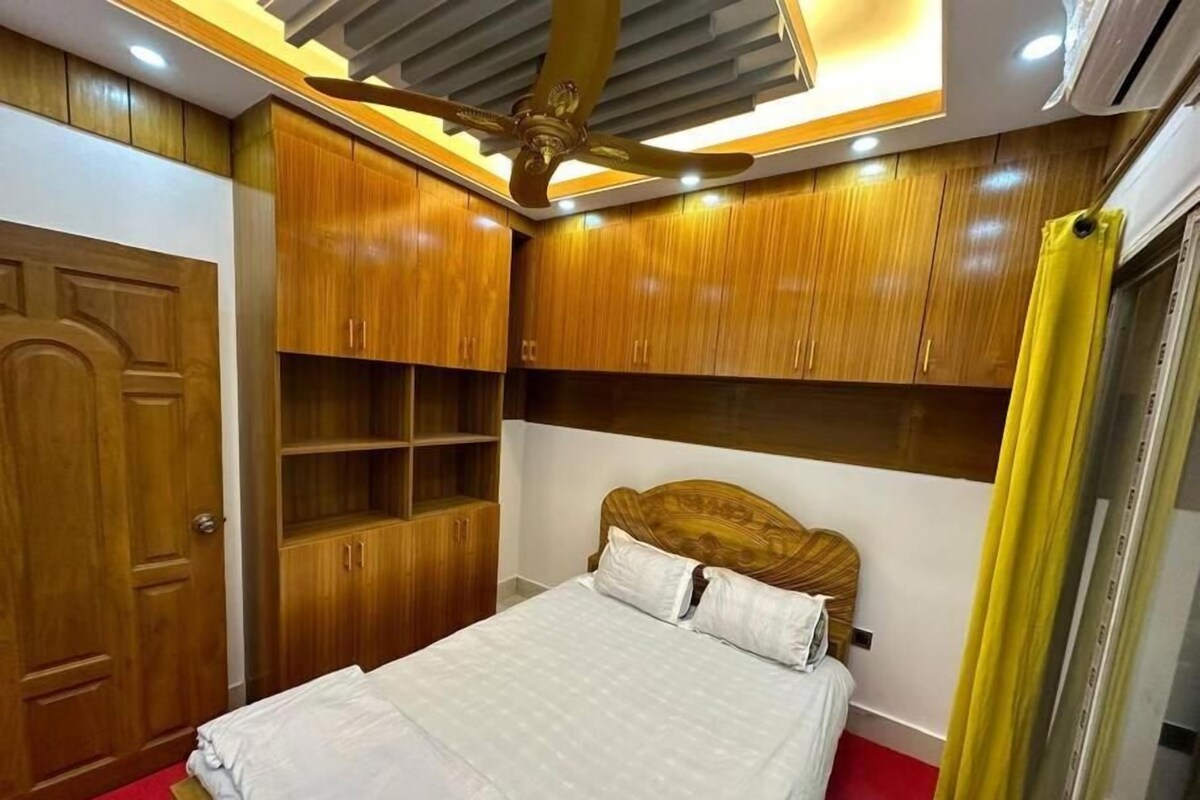 Un dormitorio con cama, armario de madera y estanterías empotradas.