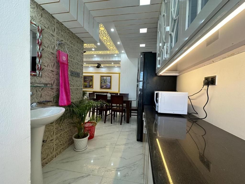 A hotel lobby with a reception desk, a sink, a dining area, and a decorative ceiling.