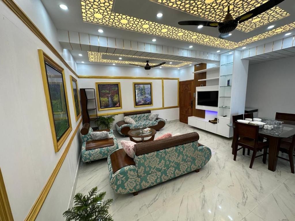 A modern living room with a sofa set, a dining table, and a TV.