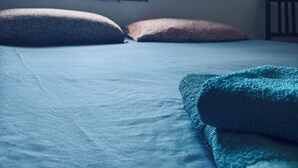 A simple room with a bed, pillows, and a window. - La Luna Guest House (Castellammare del Golfo)