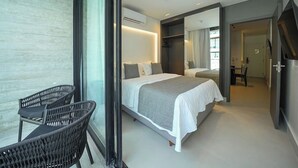 A modern hotel room with a large bed, a separate seating area with a chair, and a walk-in closet. - Gav Porto Alto Resorts (Ipojuca)
