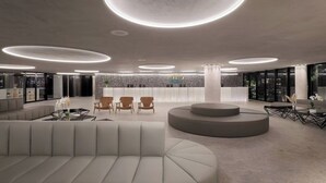 A modern lobby with a central seating area, a reception desk, and a stone accent wall. - Gav Porto Alto Resorts (Ipojuca)