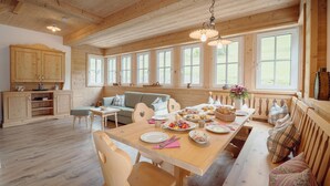 A wooden interior with a dining table set for a meal, a sofa, and a bench. - Chalet Near Lake Grundlsee & Ski Lift (Grundlsee)