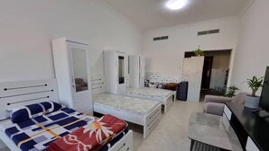 A compact bedroom with a bed, a desk, and a wardrobe. - Unique Hostel Dubai (Dubai)