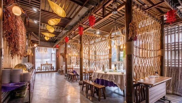 A restaurant with a rustic interior, wooden beams, and tables set for dining.