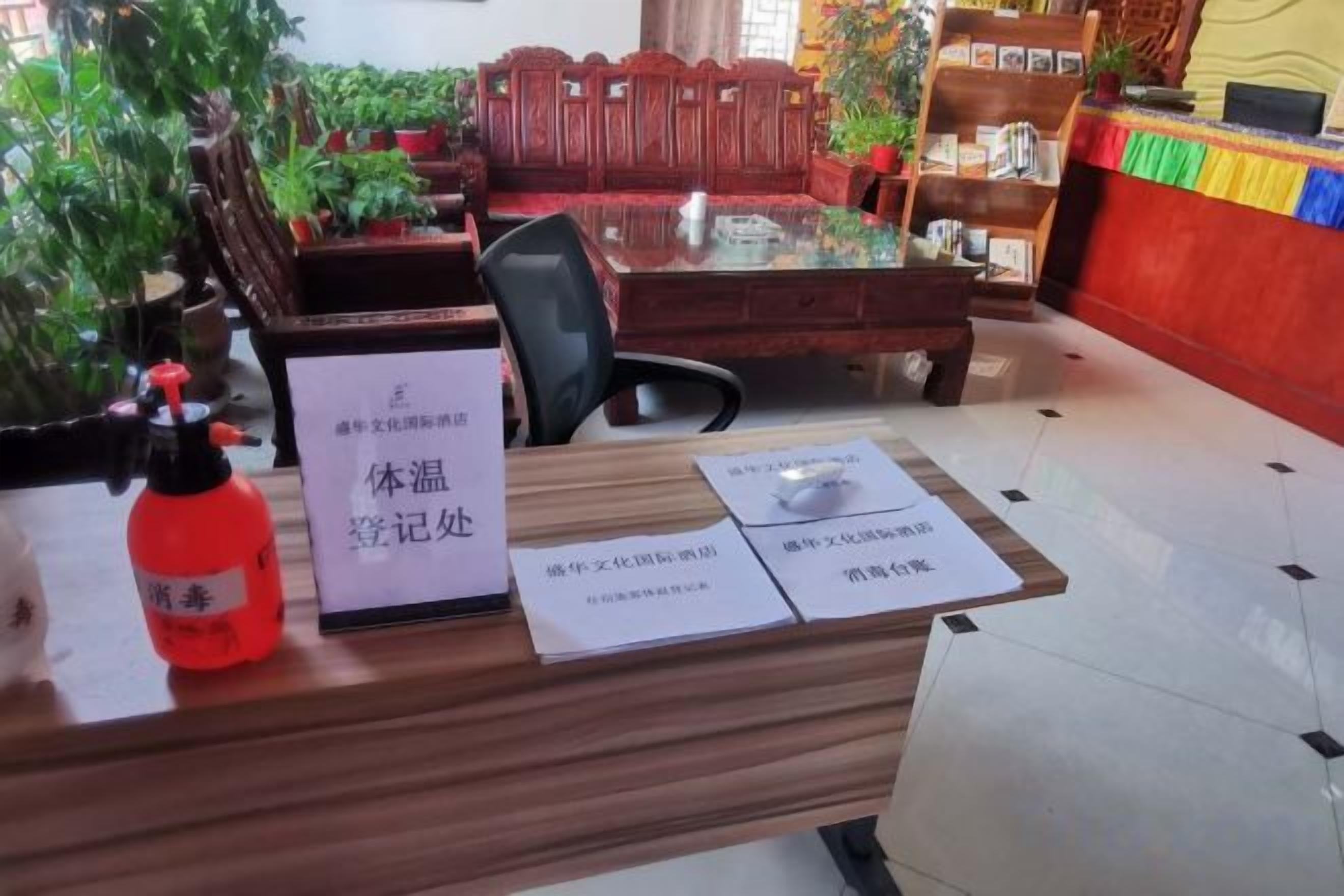 A reception desk with a sign, a fire extinguisher, and a chair.