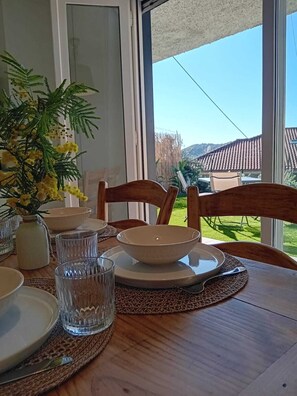 Et spisebord dækket med skåle, glas og en vase med gule blomster.