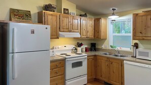 A kitchen with wooden cabinets, a white refrigerator, a stove, and a sink. - 3BD/2BA, Walkable, Family/Dog Friendly, Deck, BBQ, WIFI in Quaint Rockaway Beach (Rockaway Beach)
