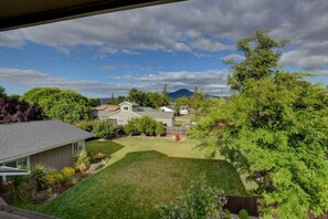 A residential property with a well-maintained lawn, a small shed, and a variety of trees and shrubs. - Beautiful Loft Apartment w/Views in Medford, OR! (Medford)