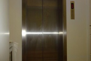An elevator with a metallic finish and a digital display on the wall. - Yuejia Hotel (Shanghai Minhang Jiaoda) (Shanghai)