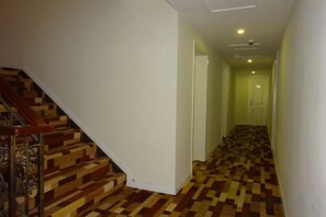 A hallway with a wooden staircase on the left and a patterned carpet. - Yuejia Hotel (Shanghai Minhang Jiaoda) (Shanghai)