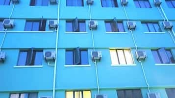 En byggnad med flera våningar, där luftkonditioneringsaggregat är monterade på utsidan av varje fönster.