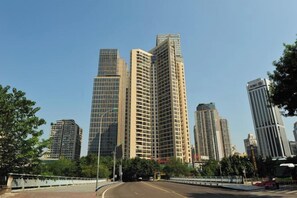 A cityscape with high-rise buildings, a clear sky, and a road with a white fence. - Chongqing Gangli Hotel (Nanping Convention and Exhibition Center Branch) (Chongqing)