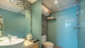 Un baño con lavamanos, inodoro y ducha.