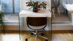 A modern office space with a white desk, a brown chair, and a potted plant. - L'Échappée Parisienne - Canal St-Denis (Aubervilliers)