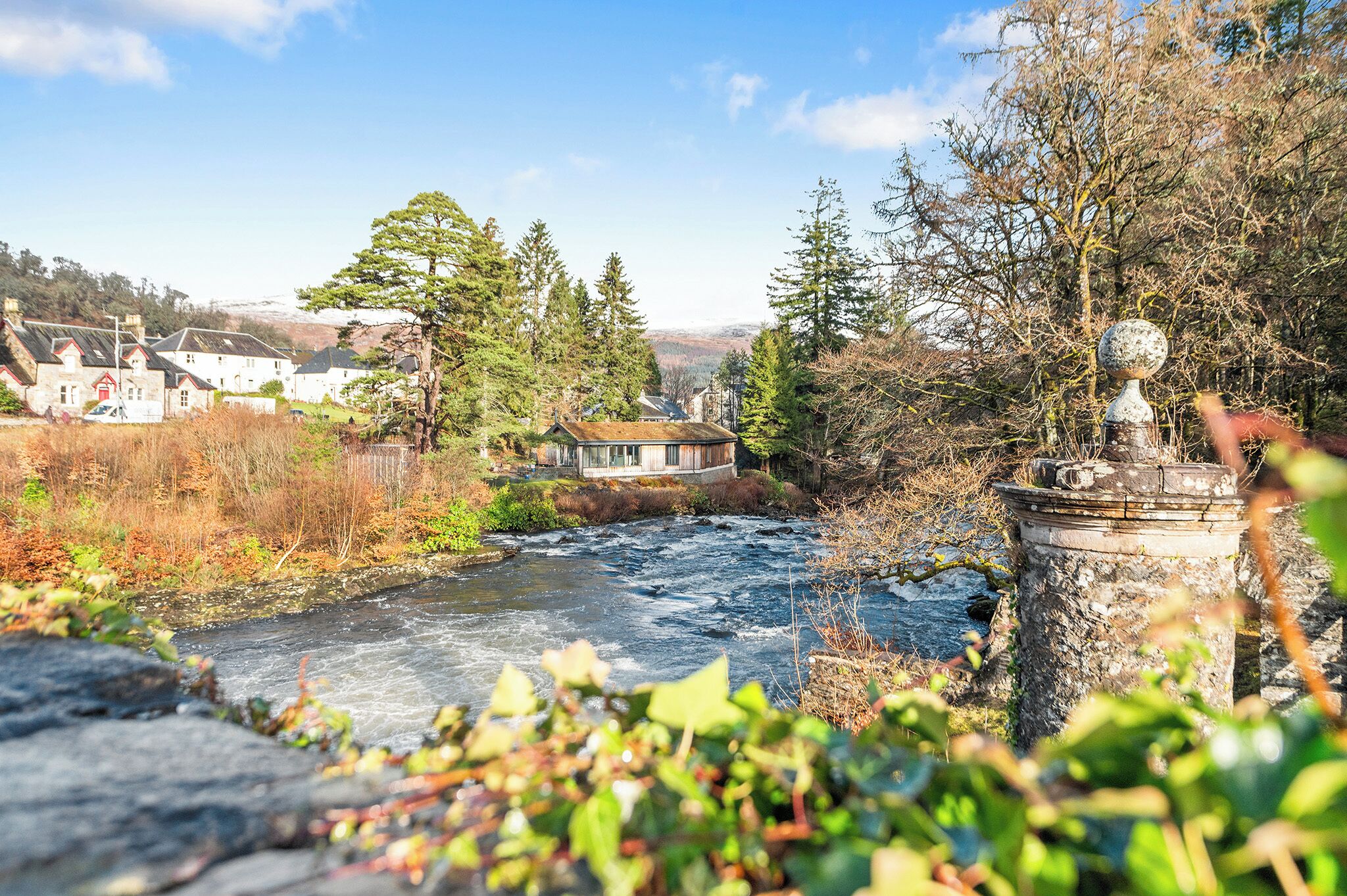 Un río que atraviesa un pueblo con casas y árboles.