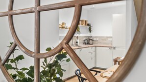 Ett modernt kök med vita skåp, en träbänkskiva och en matplats med ett bord och stolar.