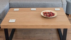 A modern living room with a grey sofa, red cushions, a wooden coffee table with a bowl of dried flowers, and patterned coasters. - Bright & Spacious 4BR House | Elizabeth Line - Pass the Keys (London)