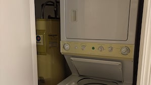 A compact, white front-loading washing machine with a control panel featuring multiple dials and buttons.
