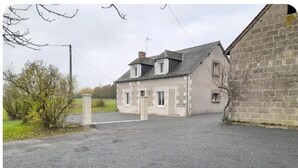 A two-story stone house with a paved driveway and a small garden area. - Le Paradis near Beauval. (Orbigny)