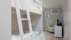 A bunk bed with a desk and chair, a radiator, and a picture on the wall. - Oceanfront Bliss: Sand and Views at Watchin' Waves (North Topsail Beach)