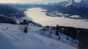 A snow-covered landscape with a lake and mountains in the background. - Hut for skiing or hiking (Pill)