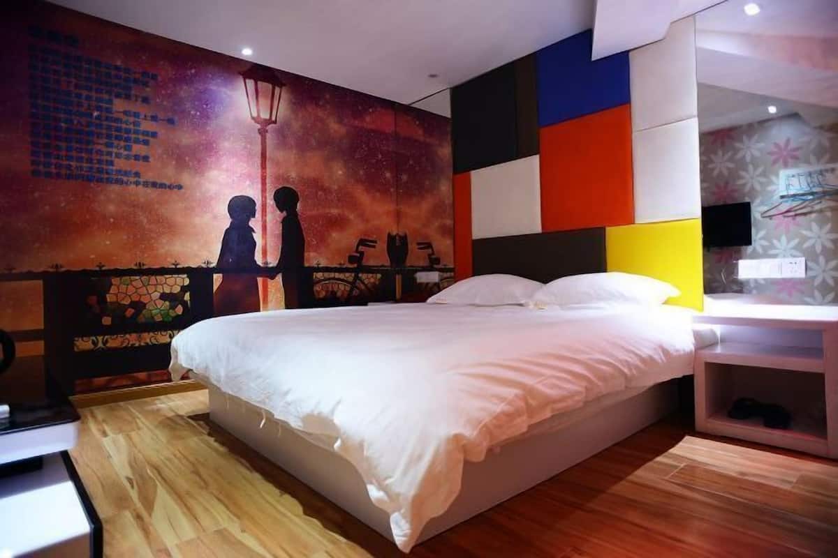 Une chambre avec un grand lit, une table de chevet, une fresque murale et un plancher en bois.