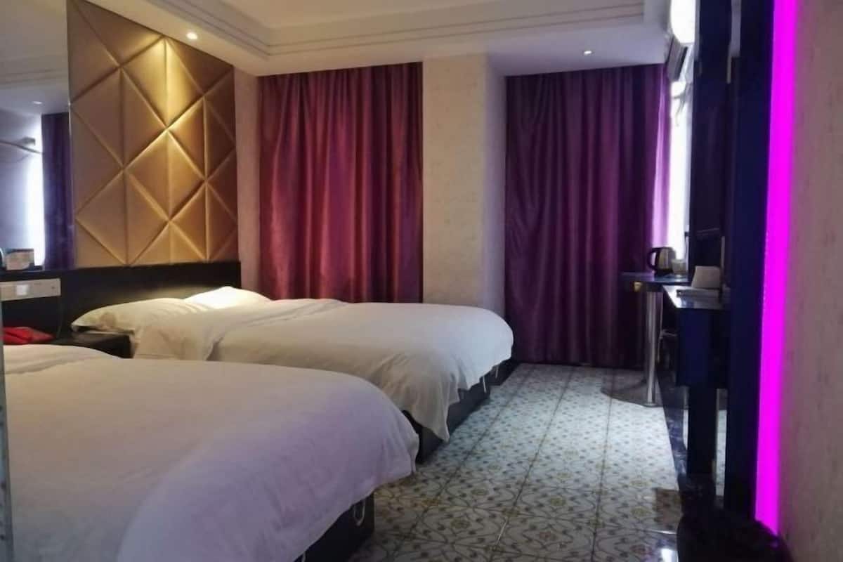 Une chambre d’hôtel avec deux lits, un bureau et un mini-bar.