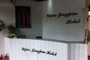 A reception desk at Yijia Jingpin Hotel with a digital display above it. - Yijia Boutique Hotel (Shanghai)
