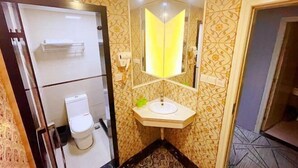 Une salle de bain avec des toilettes, un lavabo et un miroir.