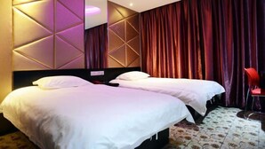 Une chambre d’hôtel avec deux lits, un grand miroir et une chaise rouge.
