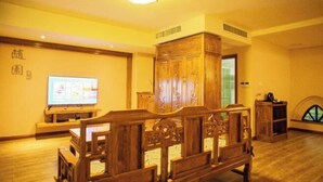 Um conjunto de móveis de madeira tradicional em um quarto com uma televisão e um armário.