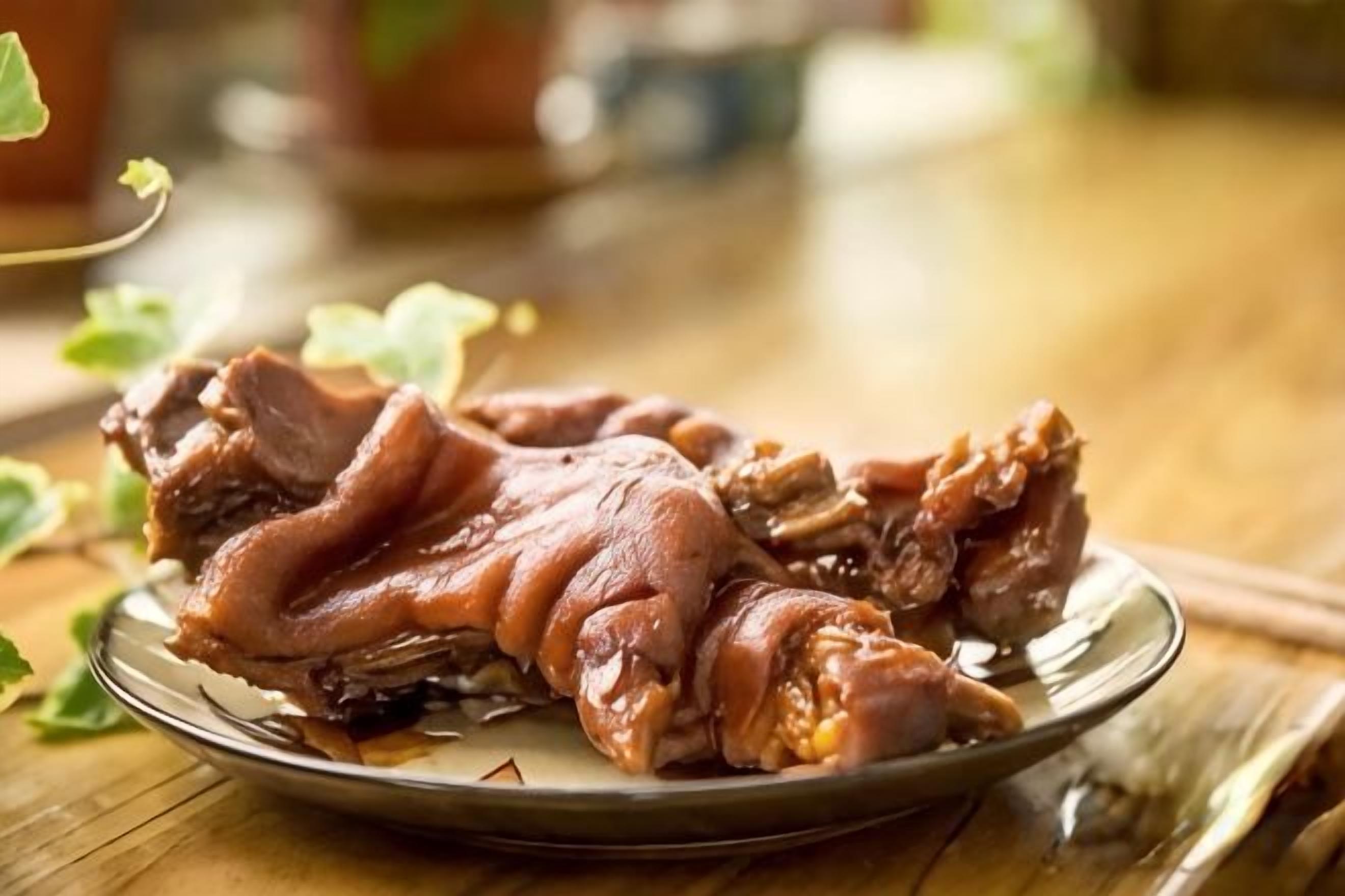 Um prato com um pedaço de carne sobre uma mesa de madeira.