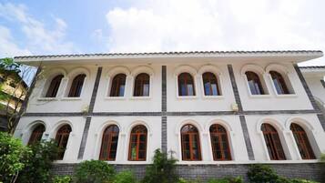 Um edifício de vários andares com fachada branca e diversas janelas em arco.