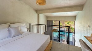 A bedroom with a large bed, a balcony with a pool, and a view of the outdoors. - Kallithea Village (Kassandra)