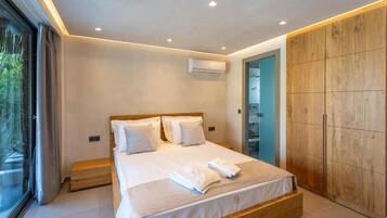 Une chambre moderne avec un grand lit, une armoire en bois et un appareil de climatisation.