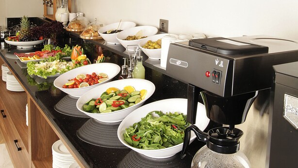 A buffet setup with various food items and a coffee machine. - Tress Hotel (Istanbul)