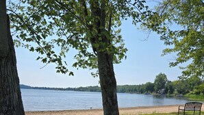 Um parque com um banco e vista para um lago.