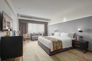 A modern hotel room with a large bed, a desk, a chair, and a TV. - Dashen Hotel(Foshan Lecong Furniture City) (Foshan)